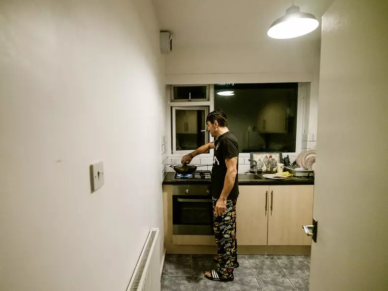 Vasile Bolohan își pregătește cina în apartamentul său din Leeds, UK