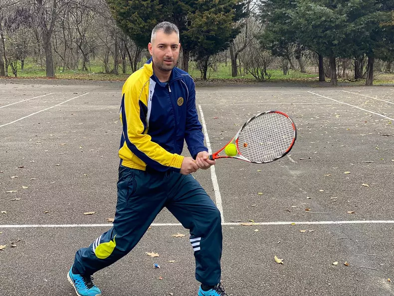 Sebastian-Constantin Popescu, îmbrăcat în trening cu o rachetă de tenis