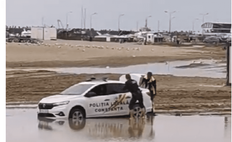 VIDEO. Mașină a Poliției Locale Constanța blocată în nisip, pe plajă. Un agent umblă desculţ, iar altul şi-a pus saci de gunoi peste încălţăminte