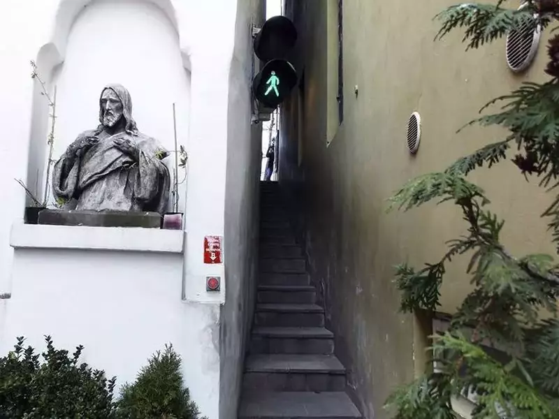 Strada unde pietonii așteaptă la semafor ca să poată trece