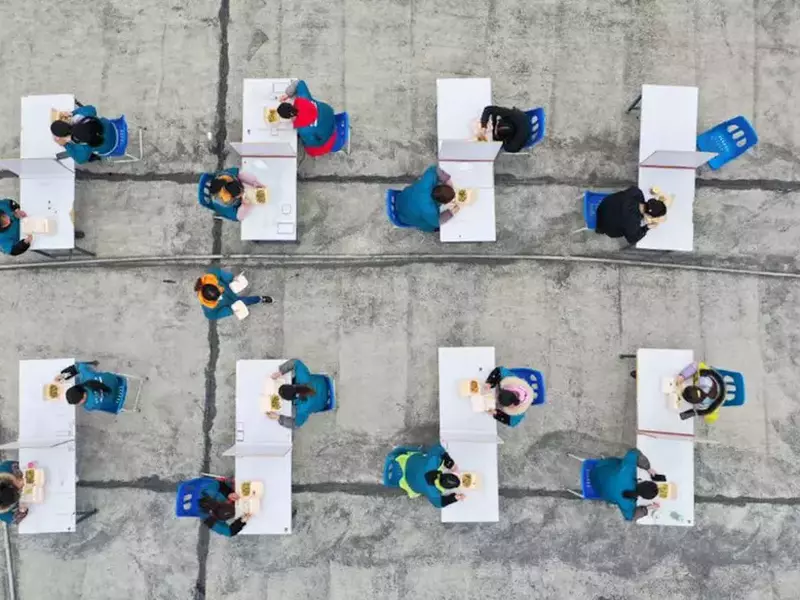 Muncitorii unei fabrici din orașul chinez Suining iau prânzul pe acoperiș, unde circulația aerului ajută la prevenirea infecțiilor cu coronavirus FOTO: EPA