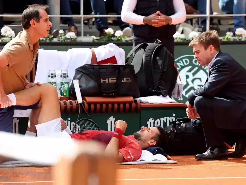Novak Djokovic consulte son kiné lors des Internationaux de France de tennis de Roland Garros 2024 à Paris