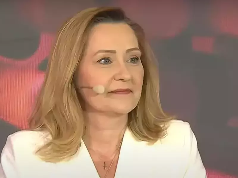 Elena Lasconi zâmbește la dezbaterea electorală, unde are rochie albă și bijuterii aurii