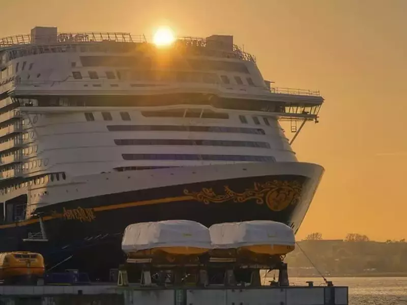 Nava de croazieră ancorată în marină, în spatele ei apune soarele