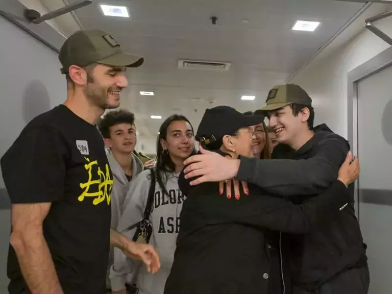 Tânărul israeliano-american, îmbrăcat sport, in hanorac si pantalon negre, se intalneste cu familia sa si se imbratisează cu mama