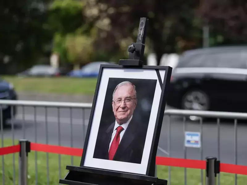 imaginea lui ion iliescu, într-o ramă neagră cu o banderolă neagră pe colt. rama cu imaginea este asezata într-un chenar realizat dintr-o paglică roșie, în parcarea Palatului Cotroceni, 6 august 2025