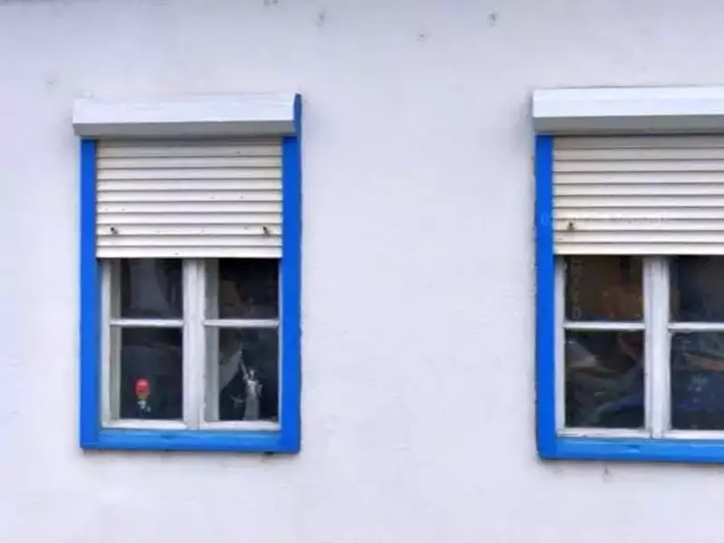 Doua ferestre albastre ale unei case albe