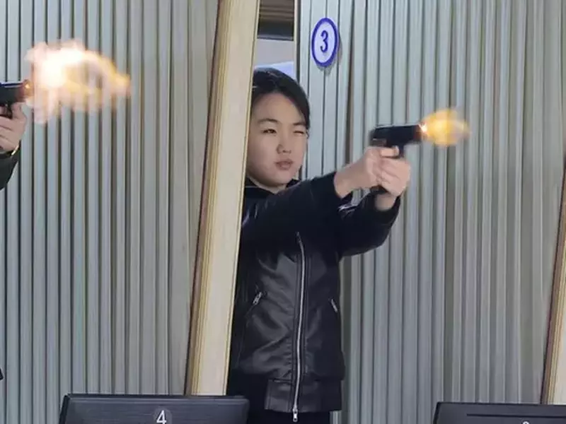 În această fotografie furnizată de guvernul nord-coreean, fiica liderului Kim Jong Un, aflată în centru, încearcă un nou pistol într-o fabrică care produce pistoale și alte arme ușoare, într-un loc necunoscut din Coreea de Nord, miercuri, 11 martie 2026.