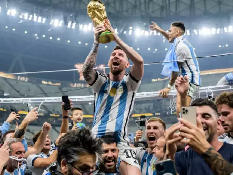 Messi este purtat pe brațe de colegii său și ține trofeul Cupei Mondiale în mâini