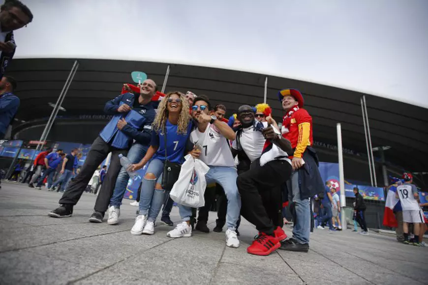 epa05355280 French and Romanian fans cheer for their teams outside the stadium before the UEFA EURO 2016 group A preliminary round match between France and Romania at Stade de France in Saint-Denis, France, 10 June 2016. (RESTRICTIONS APPLY: For editorial news reporting purposes only. Not used for commercial or marketing purposes without prior written approval of UEFA. Images must appear as still images and must not emulate match action video footage. Photographs published in online publications (whether via the Internet or otherwise) shall have an interval of at least 20 seconds between the posting.) EPA/YOAN VALAT EDITORIAL USE ONLY