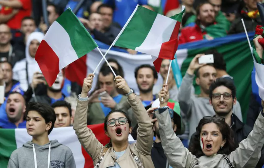 epa05362516 Supporters of Italy cheer prior to the UEFA EURO 2016 group E preliminary round match between Belgium and Italy at Stade de Lyon in Lyon, France, 13 June 2016. (RESTRICTIONS APPLY: For editorial news reporting purposes only. Not used for commercial or marketing purposes without prior written approval of UEFA. Images must appear as still images and must not emulate match action video footage. Photographs published in online publications (whether via the Internet or otherwise) shall have an interval of at least 20 seconds between the posting.) EPA/SERGEY DOLZHENKO EDITORIAL USE ONLY