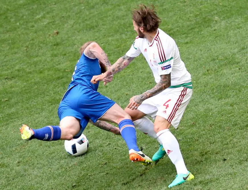 epa05375573 Tamas Kadar (R) of Hungary fouls Aron Gunnarsson of Iceland in the penalty box during the UEFA EURO 2016 group F preliminary round match between Iceland and Hungary at Stade Velodrome in Marseille, France, 18 June 2016. (RESTRICTIONS APPLY: For editorial news reporting purposes only. Not used for commercial or marketing purposes without prior written approval of UEFA. Images must appear as still images and must not emulate match action video footage. Photographs published in online publications (whether via the Internet or otherwise) shall have an interval of at least 20 seconds between the posting.) EPA/TOLGA BOZOGLU EDITORIAL USE ONLY