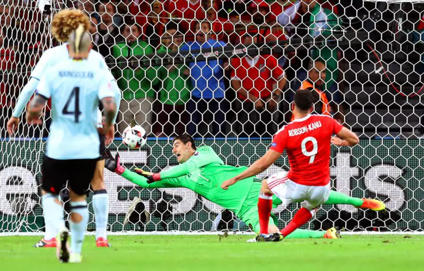 epa05402271 Hal Robson-Kanu (R) of Wales scores the 2-1 lead against Belgium's goalkeeper Thibaut Courtois (C) during the UEFA EURO 2016 quarter final match between Wales and Belgium at Stade Pierre Mauroy in Lille Metropole, France, 01 July 2016. (RESTRICTIONS APPLY: For editorial news reporting purposes only. Not used for commercial or marketing purposes without prior written approval of UEFA. Images must appear as still images and must not emulate match action video footage. Photographs published in online publications (whether via the Internet or otherwise) shall have an interval of at least 20 seconds between the posting.) EPA/LAURENT DUBRULE EDITORIAL USE ONLY