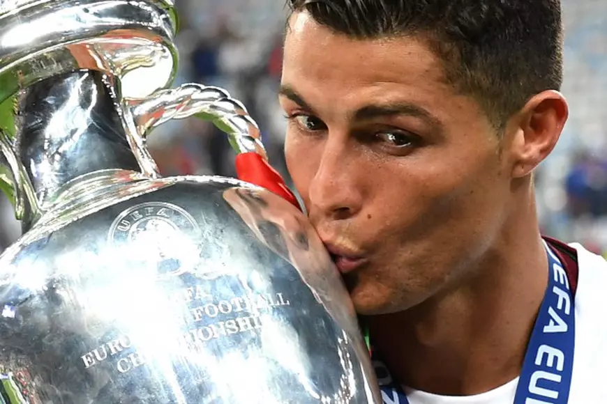 epa05419756 Cristiano Ronaldo of Portugal kisses the trophy after winning the UEFA EURO 2016 Final match against France at Stade de France in Saint-Denis, France, 10 July 2016. (RESTRICTIONS APPLY: For editorial news reporting purposes only. Not used for commercial or marketing purposes without prior written approval of UEFA. Images must appear as still images and must not emulate match action video footage. Photographs published in online publications (whether via the Internet or otherwise) shall have an interval of at least 20 seconds between the posting.) EPA/GEORGI LICOVSKI EDITORIAL USE ONLY