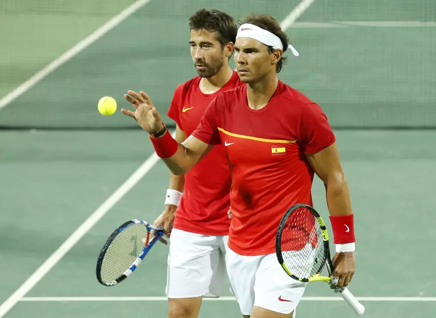 epa05469514 Rafael Nadal (L) and Marc Lopez of Spain prepare to serve during the men's doubles quartefinal match between Lopez/Nadal of Spain and Marach/Peya of Austria of the Rio 2016 Olympic Games Tennis events at the Olympic Tennis Centre in the Olympic Park in Rio de Janeiro, Brazil, 09 August 2016. EPA/MICHAEL REYNOLDS