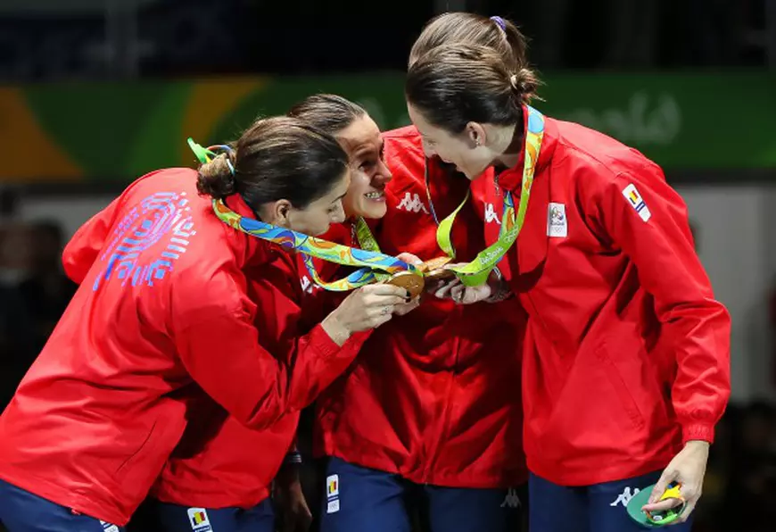epa05475572 Members of team Romania (L-R) Loredana Dinu, Simona Gherman, Simona Pop, and Ana Maria Popescu celebrate with their gold medals on the podium after winning the women's Epee Team competition of the Rio 2016 Olympic Games Fencing events at the Carioca Arena 3 in the Olympic Park in Rio de Janeiro, Brazil, 11 August 2016. EPA/JOSE MENDEZ