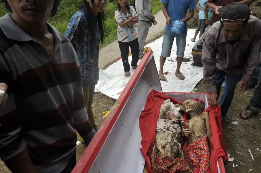 Family Members Change Cloths Of Their Dead Ancestors