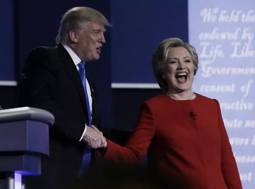 Hillary râde mulțumită de rezultatul prime dezbateri prezidențiale, în timp ce îi strânge mâna lui Donald Trump