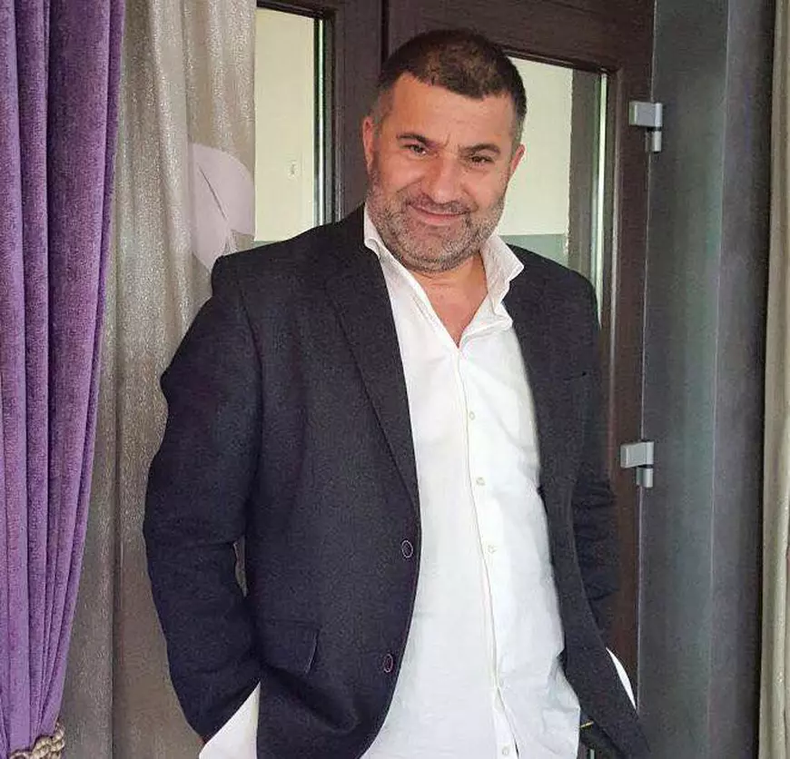 Ioniță de la Clejani, îmbrăcat la costum, afișează un zâmbet larg pe chip