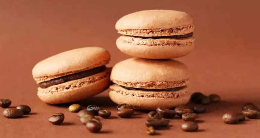 43390858 - coffee macarons with coffee beans on brown background