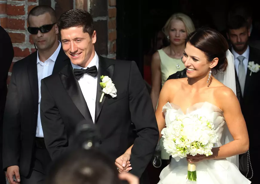 epa03755445 Polish national soccer team and German Bundesliga, Borussia Dortmund, striker Robert Lewandowski (L) and his new bride Anna Stachurska (R) leave the church, after their wedding ceremony, in Serock, near Warsaw, Poland, 22 June 2013. EPA/RADEK PIETRUSZKA POLAND OUT