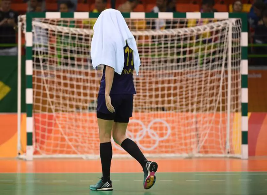 Imagine cu putere de simbol: Gabriela Perianu, ascunzâdu-se de rușine sub prosop, după eliminarea prematură a naționalei feminine de handbal a României de la Jocurile Olimpice. (FOTO: EPA)