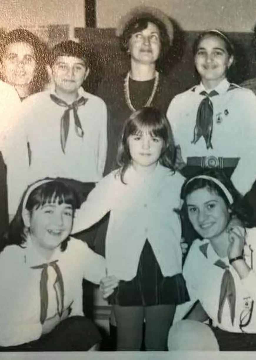 Cum arăta Manuela Hărăbor în copilărie: micuță, cu privirea caldă și ochii blânzi, în centrul imaginii, înconjurată de alți elevi