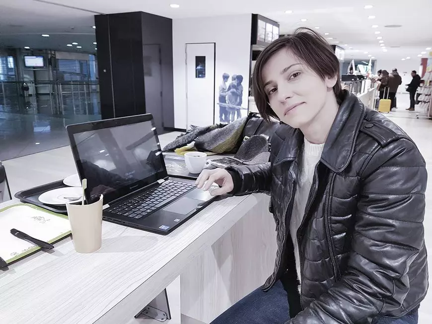 dana Rogoz, în aeroprotul din Torino, cu laptopul deschis în fața ei