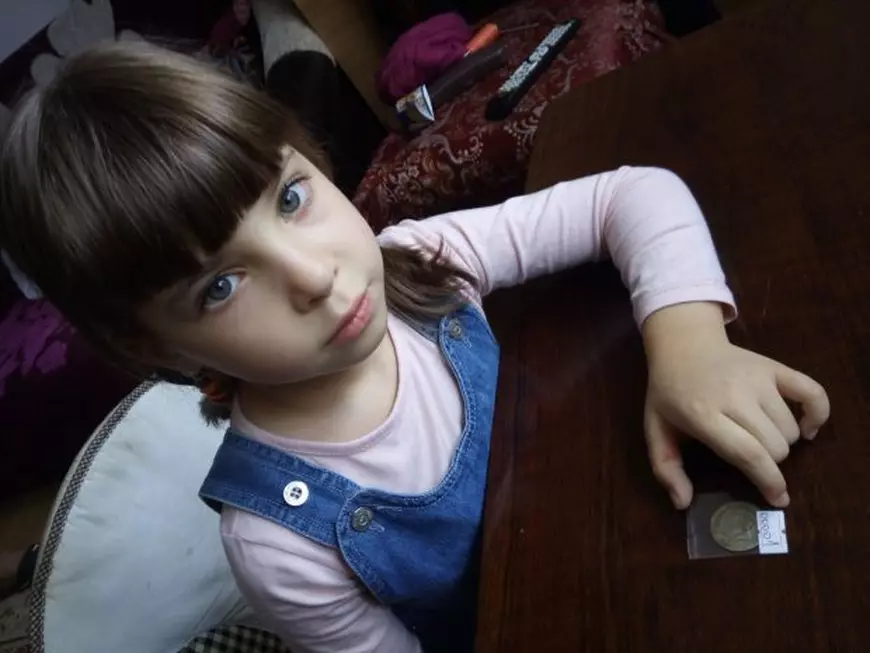 Elena, în vârstă de doar șase ani, pare să fie la fel de pasionată de numismatică. Puștoaica s-a fotografiat cu prima monedă pe care tatăl său a descoperit-o pe când era cam de vârsta ei