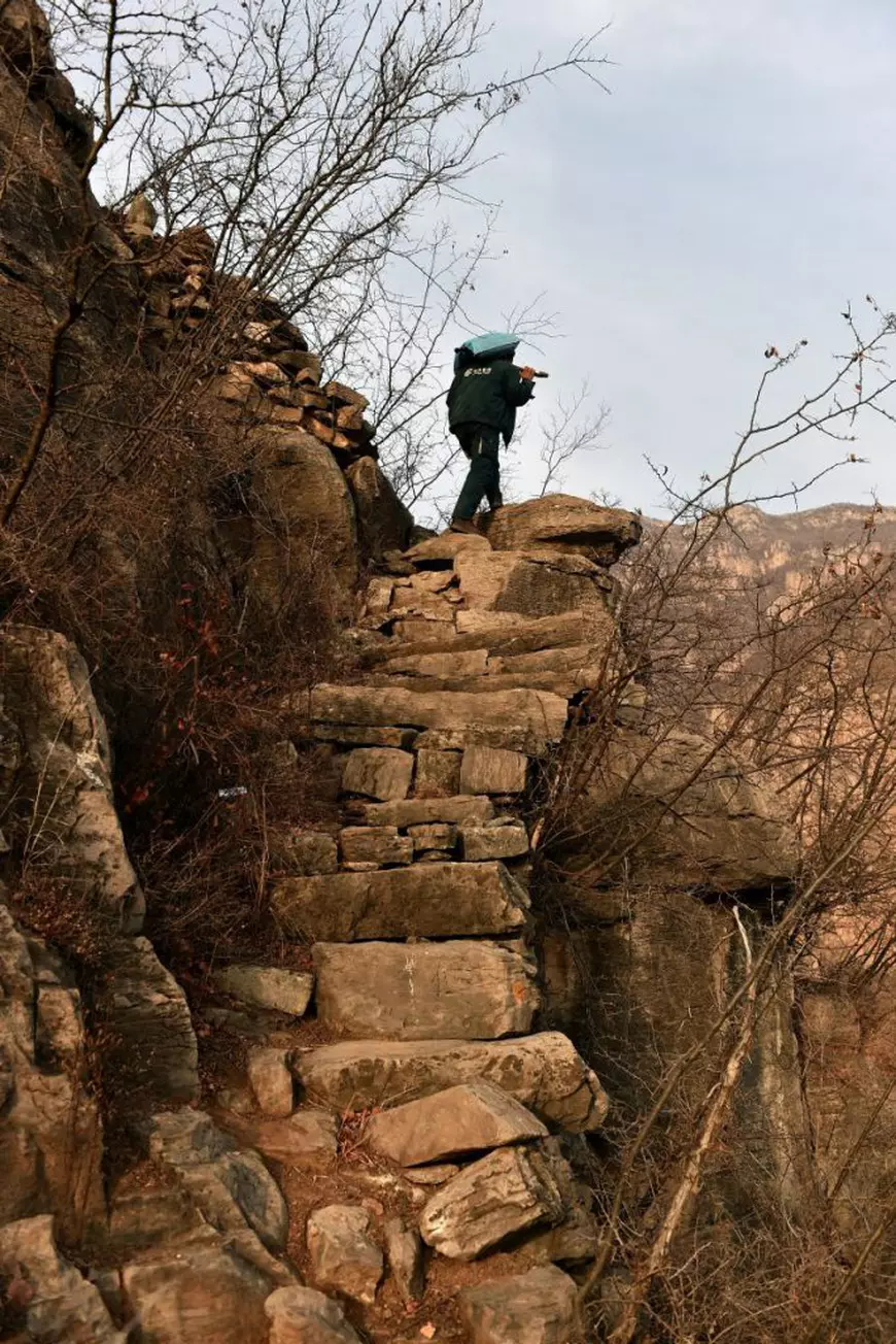 un poștaș din China se cațără zilnic pe drumuri de munte