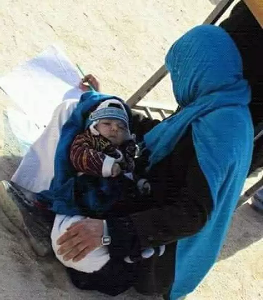 FOTO | Ipostaza care face înconjurul lumii: O tânără afgană are grijă de bebelușul ei în timp ce dă examenul pentru admitere la universitate