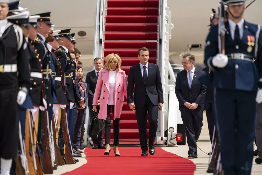Ce ținute au ales Brigitte Macron și Melania Trump. Brigitte Macron îmbrăcată în sacoul roz la coborrea din avionul prezidențial