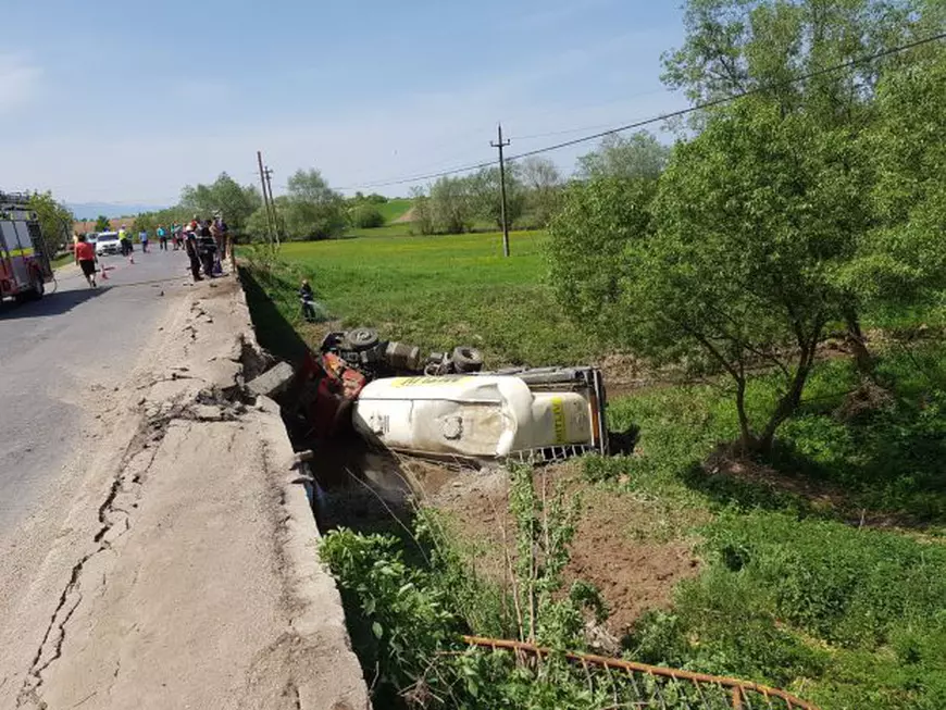 Un TIR încărcat cu ciment s-a răsturnat într-un pârâu, în judeţul Braşov. Există scurgeri de combustibil, iar şoferul a fost rănit/FOTO