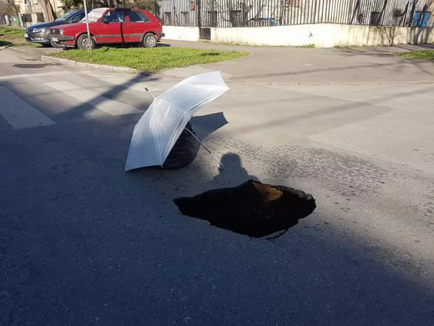 UPDATE: Un crater pe o stradă din centrul Timișoarei, semnalizat cu o umbrelă și un sac de gunoi. Scena, pozată de un consilier județean/ FOTO