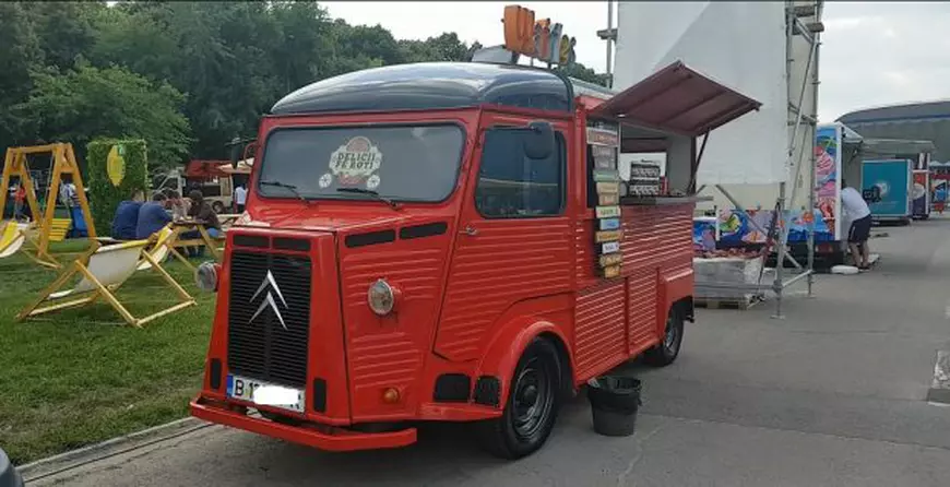 Eduard Avramescu face sendvișuri într-o bucătărie pe roți. Intr-una din mașini se gătesc waffle