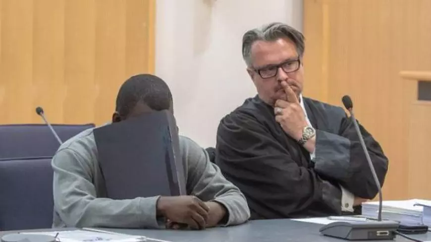 Souleymane T își ascunde fața, în momentul primirii verdictului, alături de avocatul său