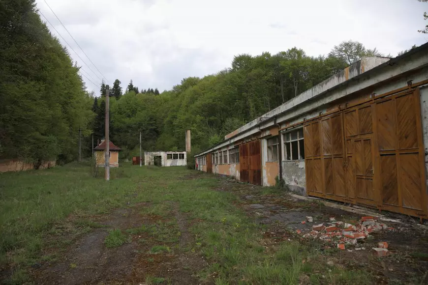 Ruinele fostei fabrici de conserve, iar în fundal este intrarea în mina care s-a închis în anul 1964