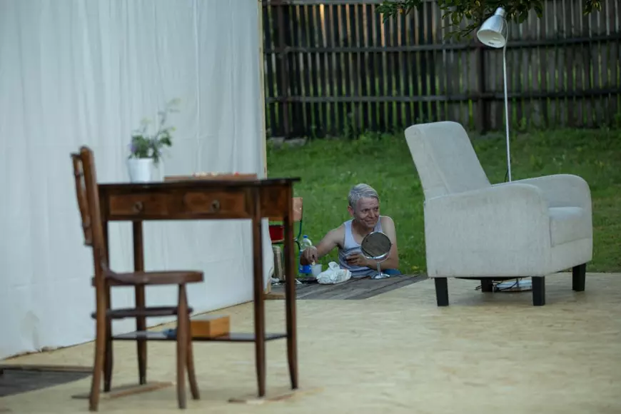 Decorul scenei este simplu: un fotoliu, un scaun și o măsuță de lemn. Actorul Iulian Gliță se pregătește pentru spectacol într-o „cabină” improvizată