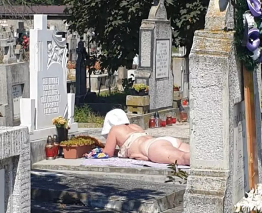 La plajă, într-un cimitir din Alba Iulia. O femeie şi-a întins pătura pe un mormânt