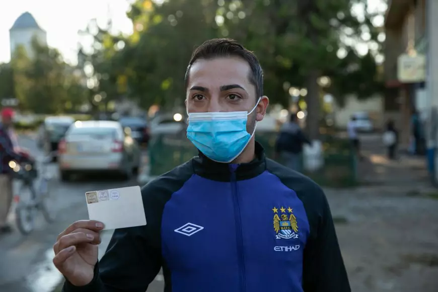 Un tânăr arată ștampila de vot de pe buletin, la ieșirea de la urne