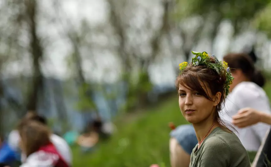 În timpul slujbei de la altarul dintre munți, o tânără și-a împletit o coroniță din flori