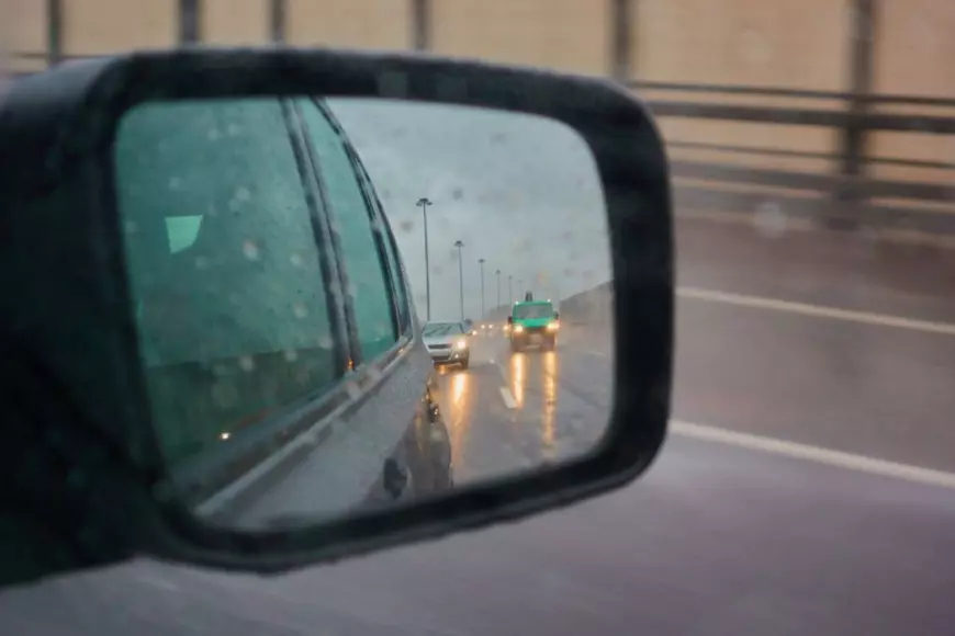 Oglinda retrovizoare a unei masini pe timp de ploaie