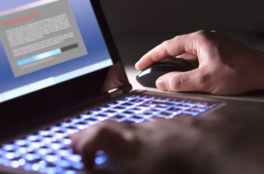 Mouse de computer- un laptop deschis si un mpuse pe care sta o mana de barbat