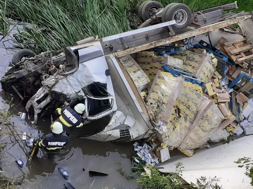 Un TIR încărcat cu dulciuri s-a răsturnat în albia unui râu din județul Vaslui, după ce i-a explodat un pneu