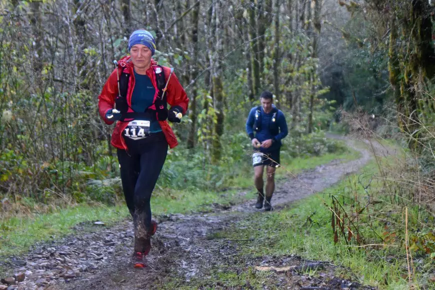 Care este cel mai greu maraton din lume - O sportivă şi un sportiv alergând pe un traseu printr-o pădure.