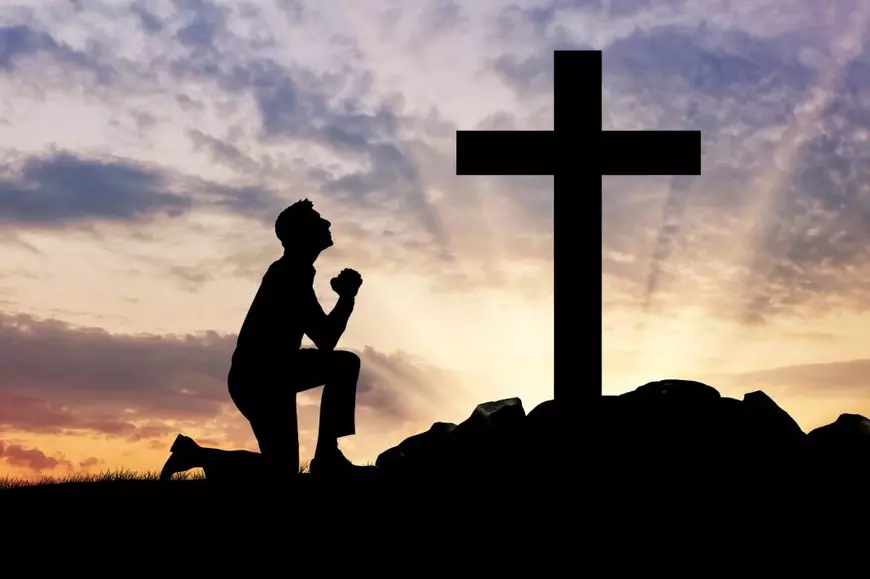 Indulgentele- Un om se roaga in fata unei cruci  