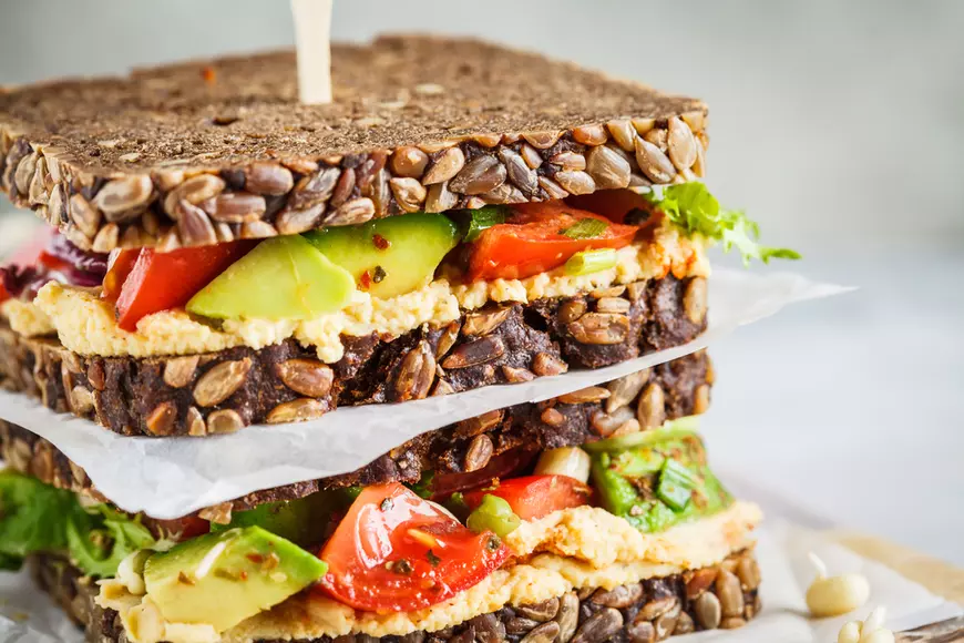 A healthy sandwich with hummus and avocado