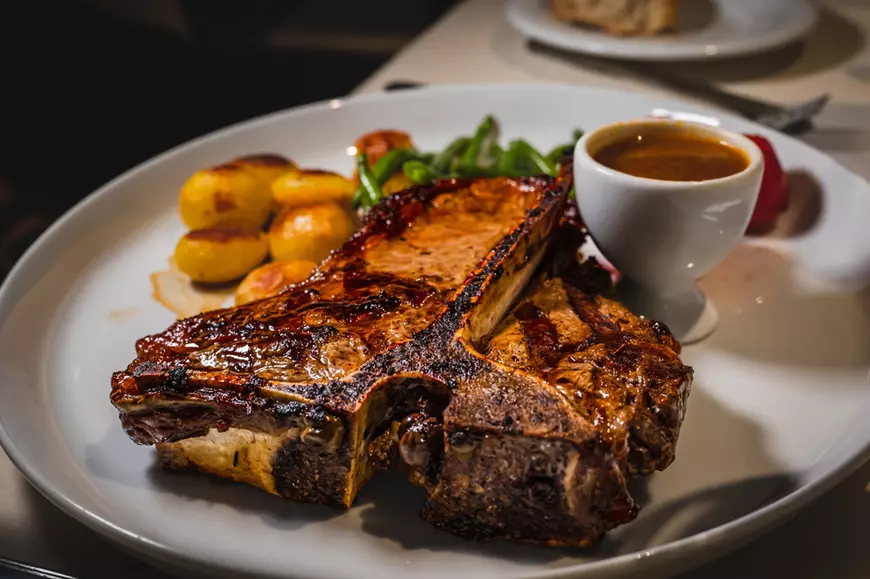 Friptură T-Bone cu ierburi și cartofi cu sos espagnole