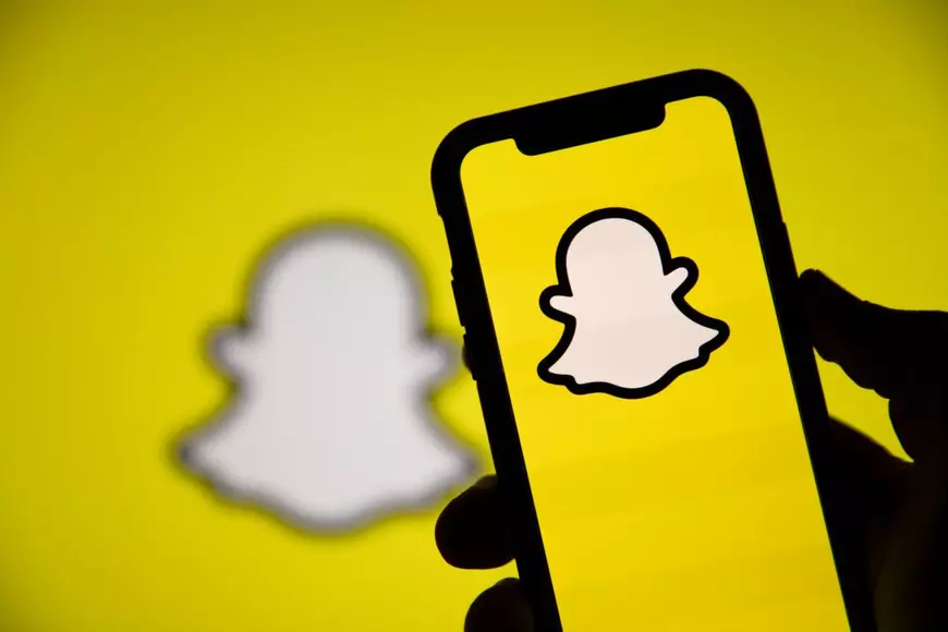 Reţele de socializare mai puţin cunoscute - Imagine cu sigla Snapchat pe un telefon