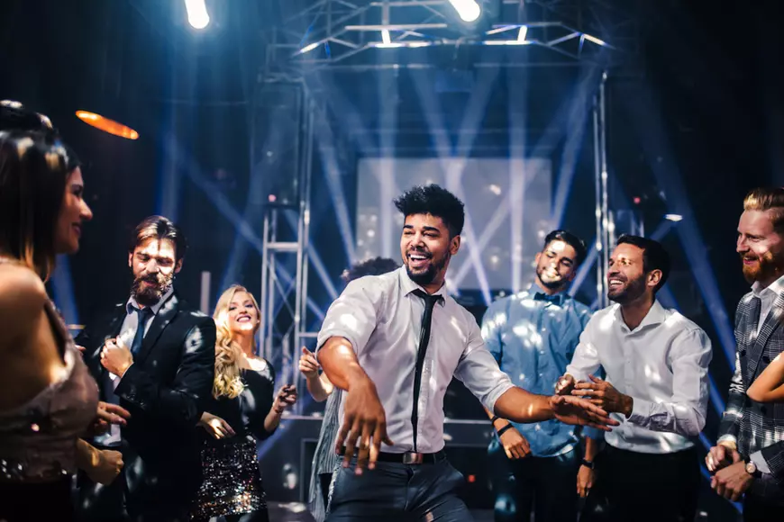 Ghid pentru organizarea unei petreceri a burlacilor - Imagine cu tineri şi tinere care dansează într-un club.
